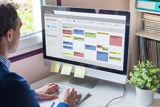 An employee managing his schedule using a computer. 
